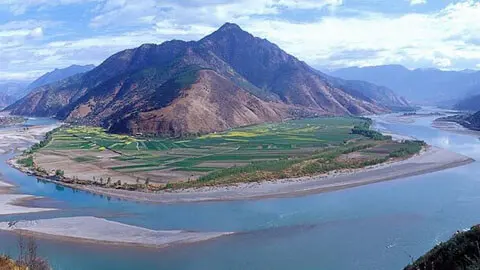 A traditional wooden boat navigating through the dramatic misty gorges of the Yangtze River