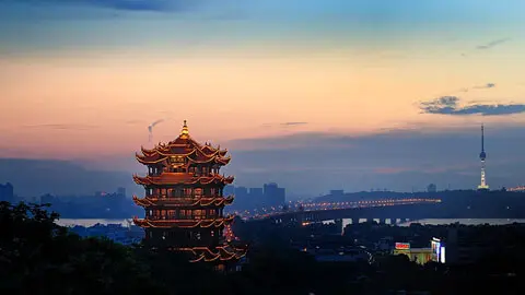 The grand multi-tiered wooden architecture of Yellow Crane Tower overlooking the river